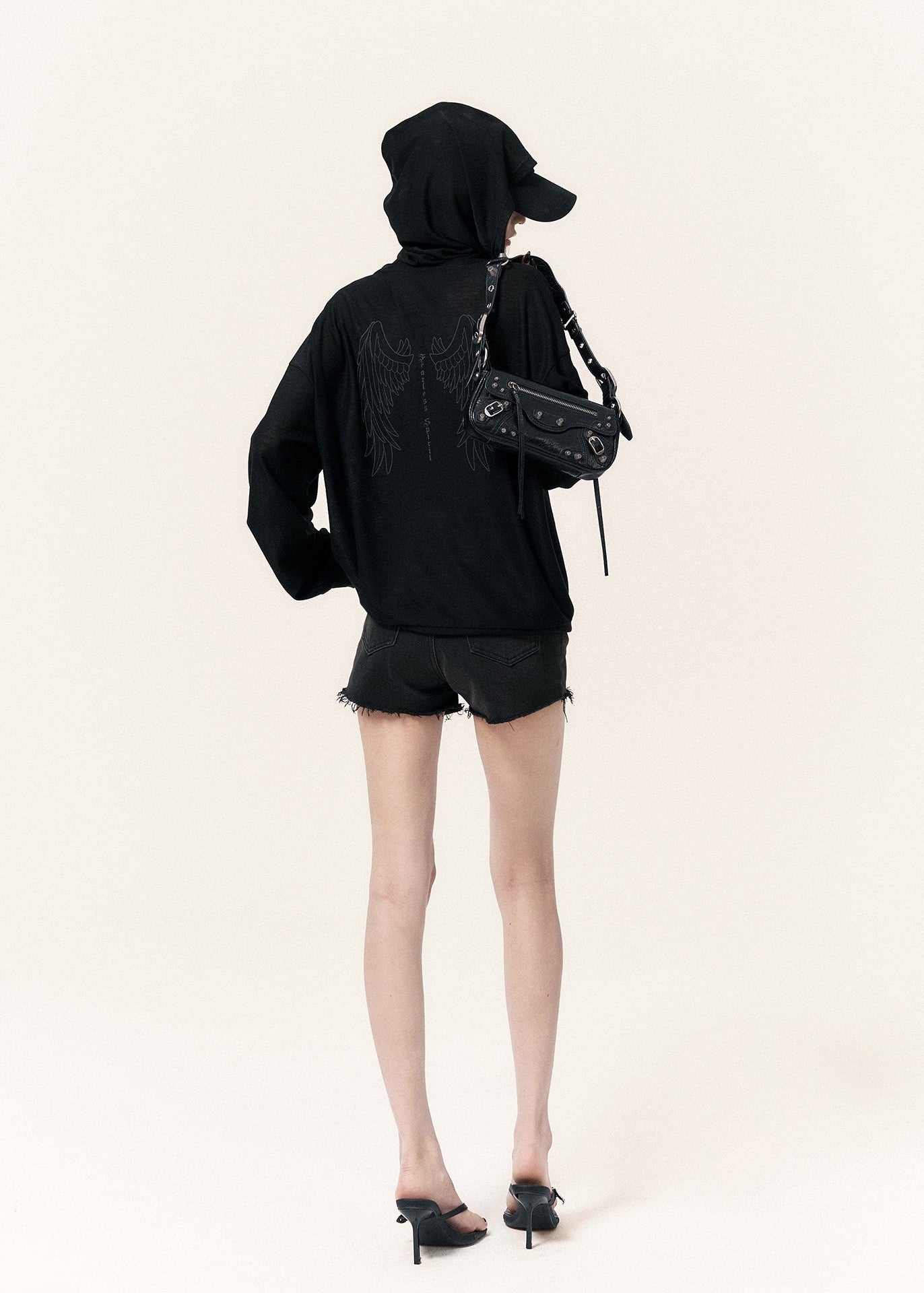 Oversized black zip-up hoodie with long sleeves and a cross-shaped zipper pull