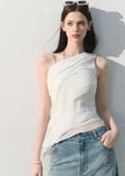 White sleeveless asymmetrical top styled with denim