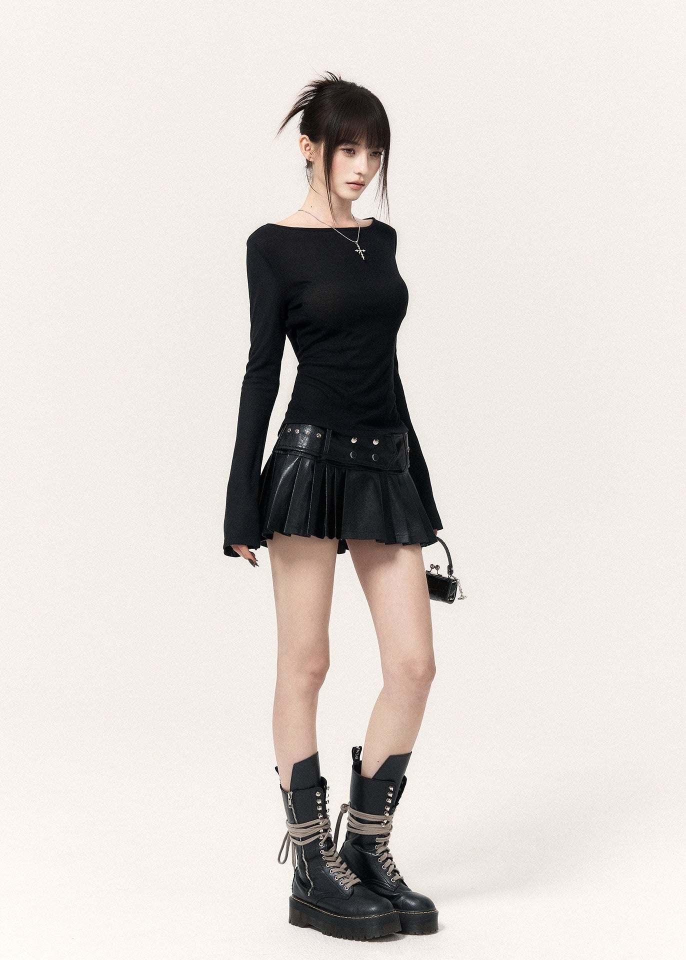 Black fitted long-sleeve top with flared cuffs styled with a pleated mini skirt