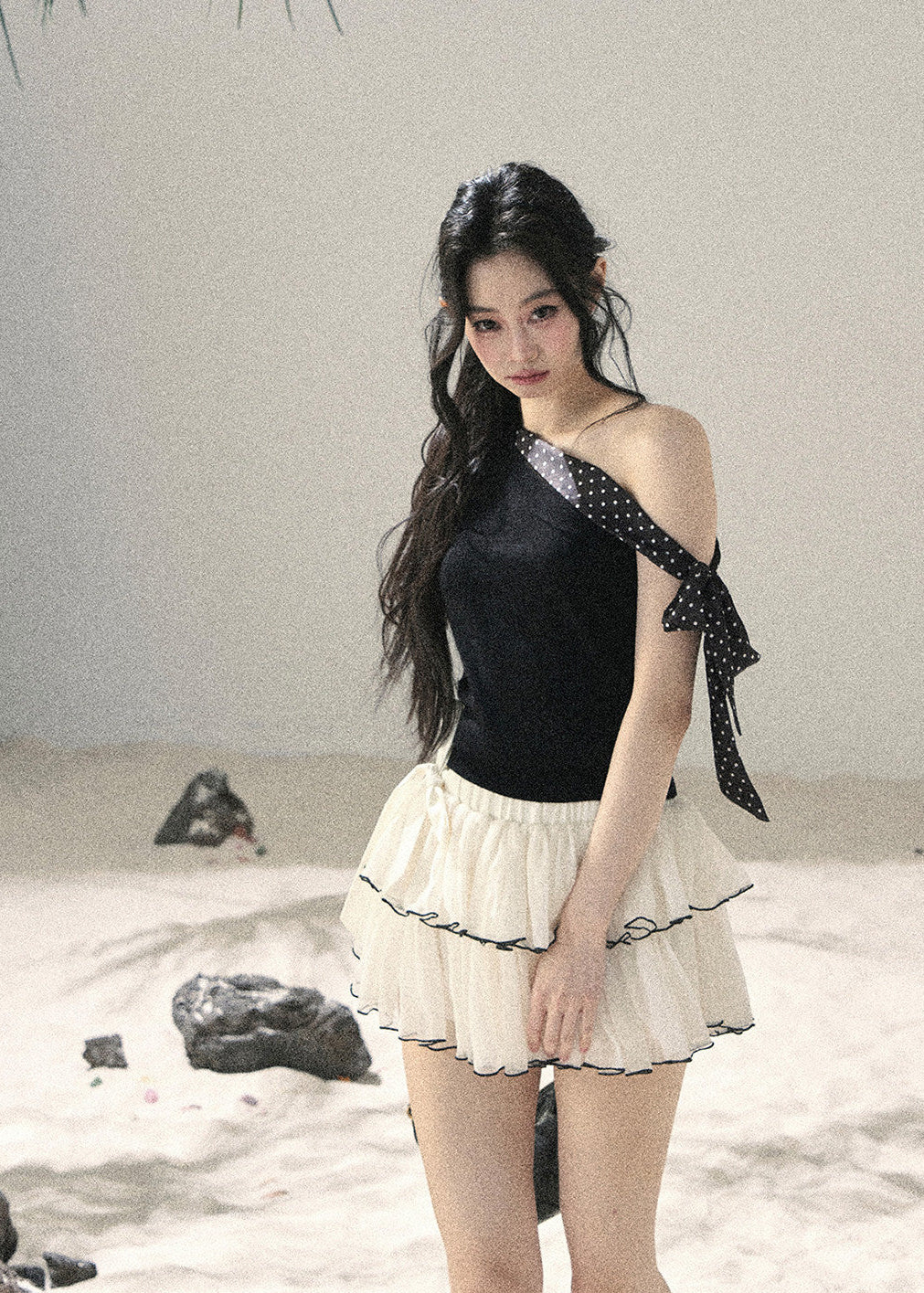 Black one-shoulder knit top with polka dot ribbon bow detail