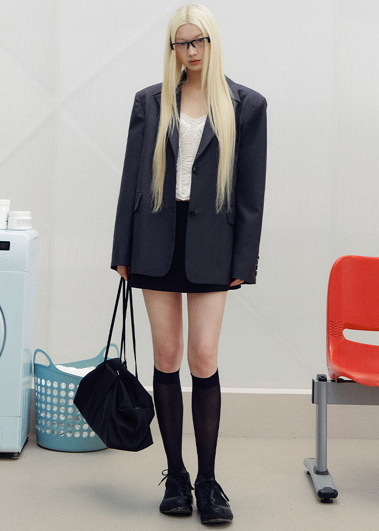 Single-breasted charcoal tailored jacket displayed against a light gray background