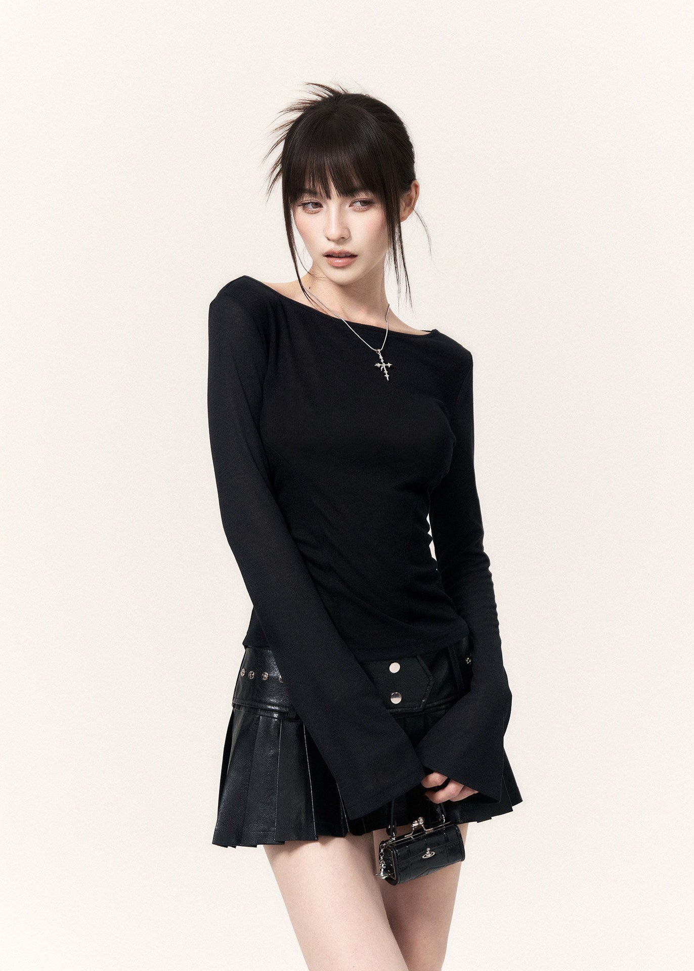 White long-sleeve top with an angel wing back print styled with a black mini skirt and cap