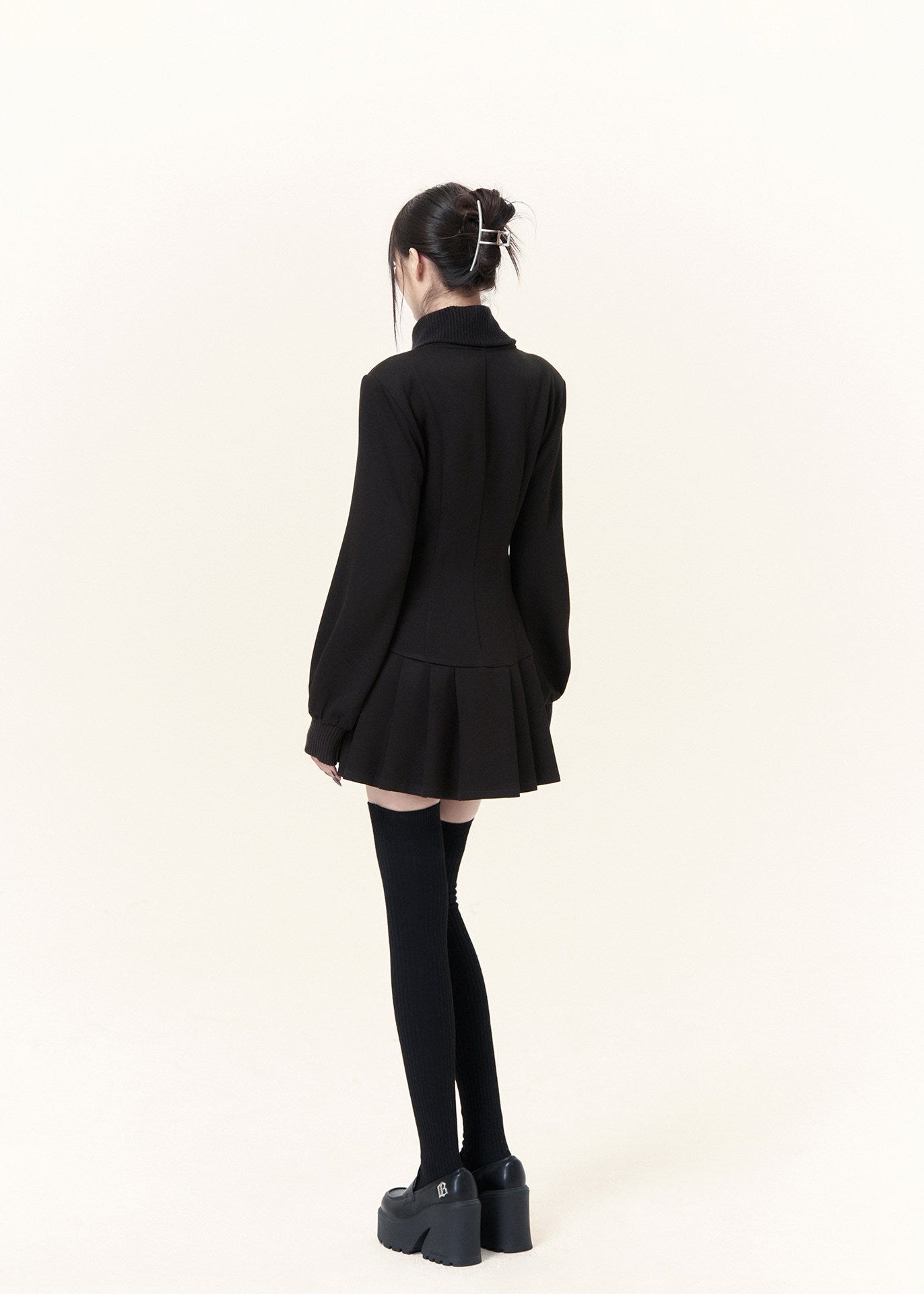 Military-inspired black mini dress with stand collar and pleated hem