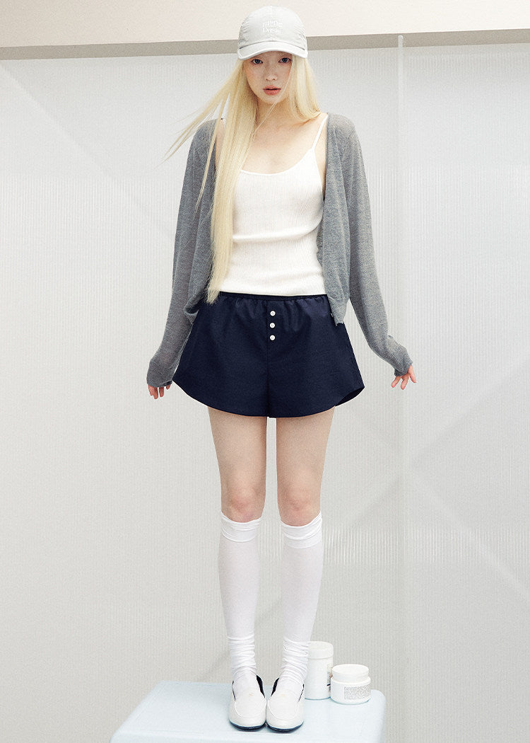 Navy button-detail shorts displayed against a light gray background
