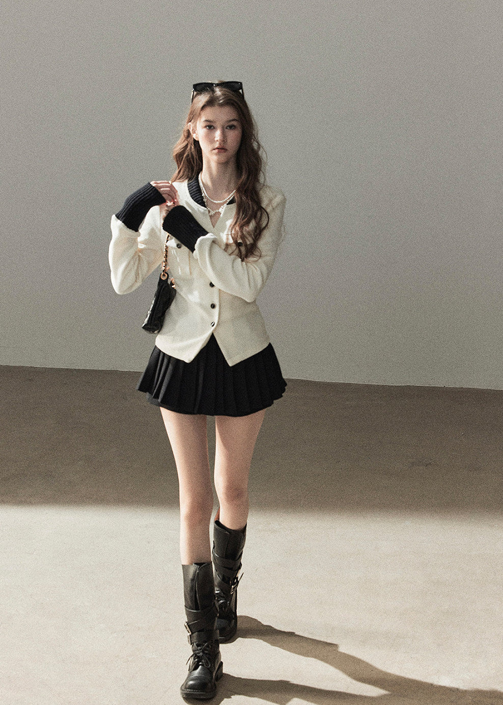 Ivory contrast trim waffle knit cardigan with black pleated mini skirt