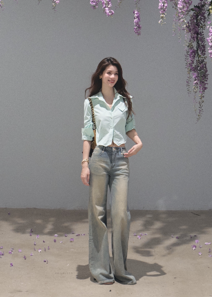 Woman wearing a lilac cropped cotton shirt with folded sleeves