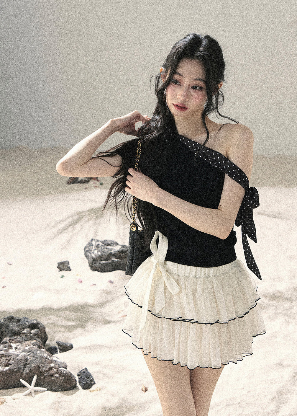 Black one-shoulder knit top with polka dot ribbon bow detail