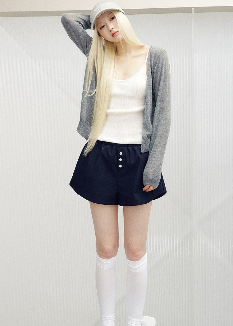 White ribbed camisole with slender straps styled with a gray cardigan and dark shorts