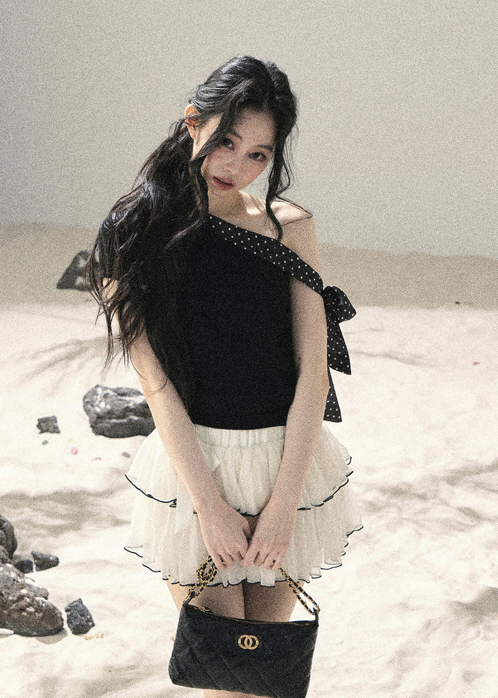 Black one-shoulder knit top with polka dot ribbon bow detail