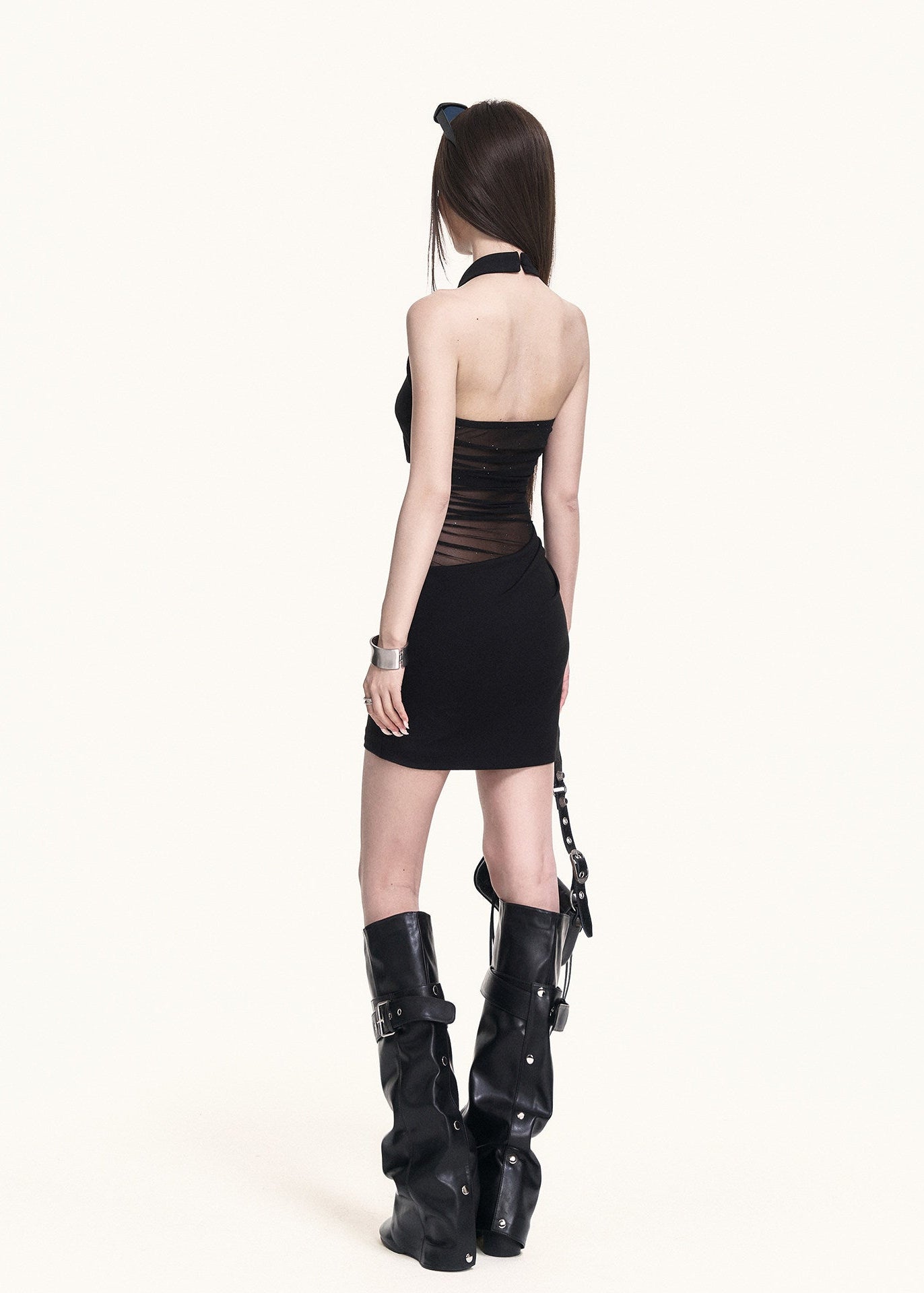 Black mini dress styled with tall boots and a shoulder bag